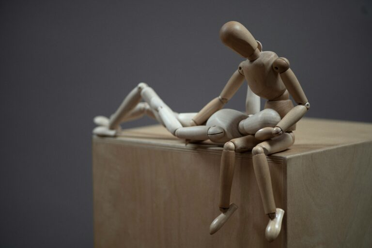 Zwei Holzfiguren in fürsorglicher Pose. © Foto von Marco Bianchetti auf Unsplash