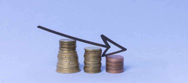 abnehmende Stapel von Münzen vor hellblauem Hintergrund © freepik