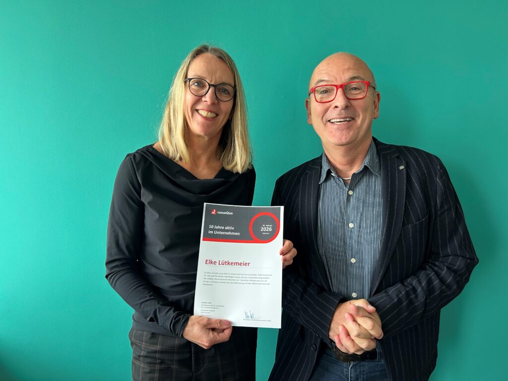 Elke Lütkemeier mit Urkunde und Udo Halwe vor grüner Wand